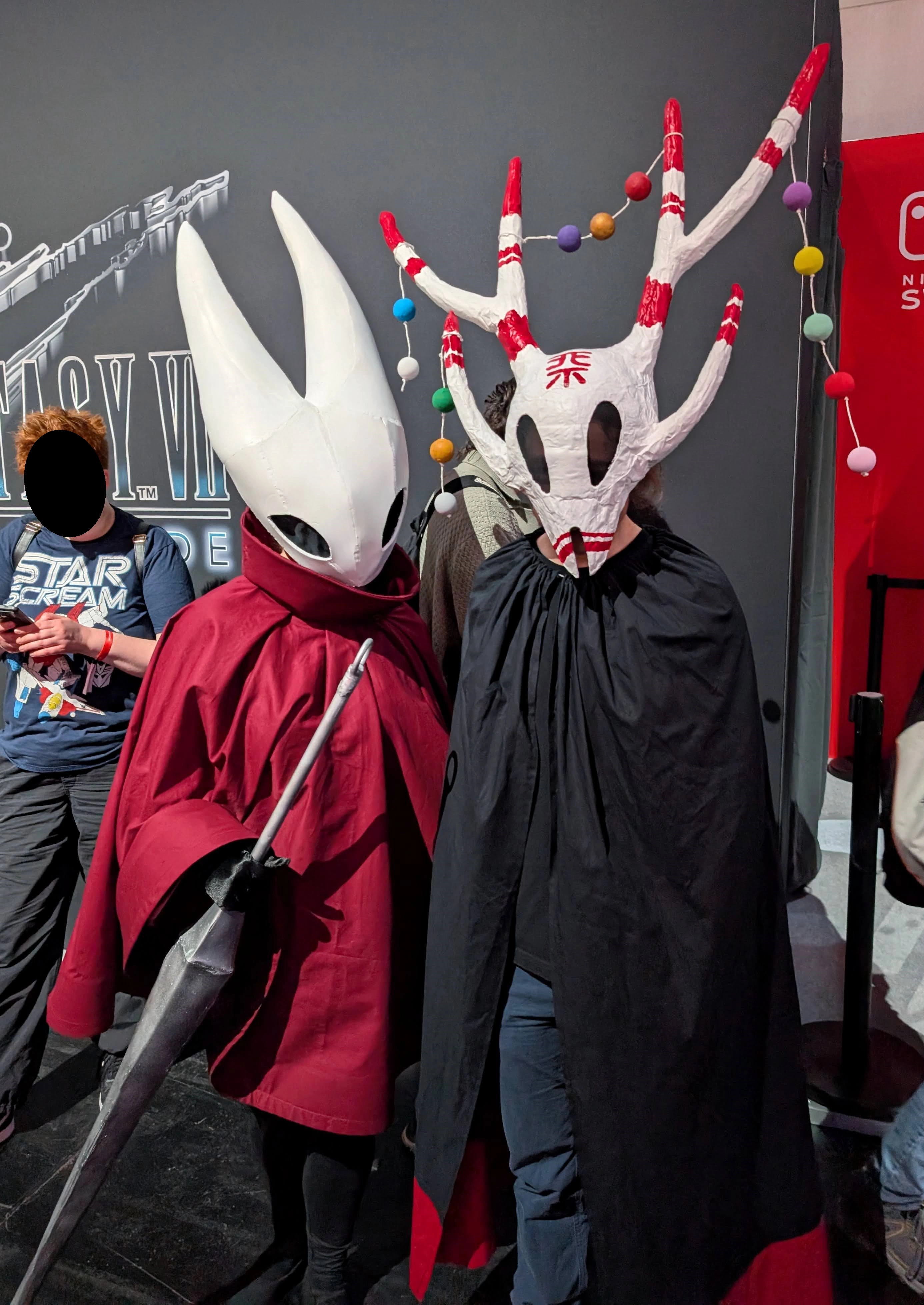 A selfie of myself wearing the outfit, with someone cosplaying Hornet from Silksong next to me.